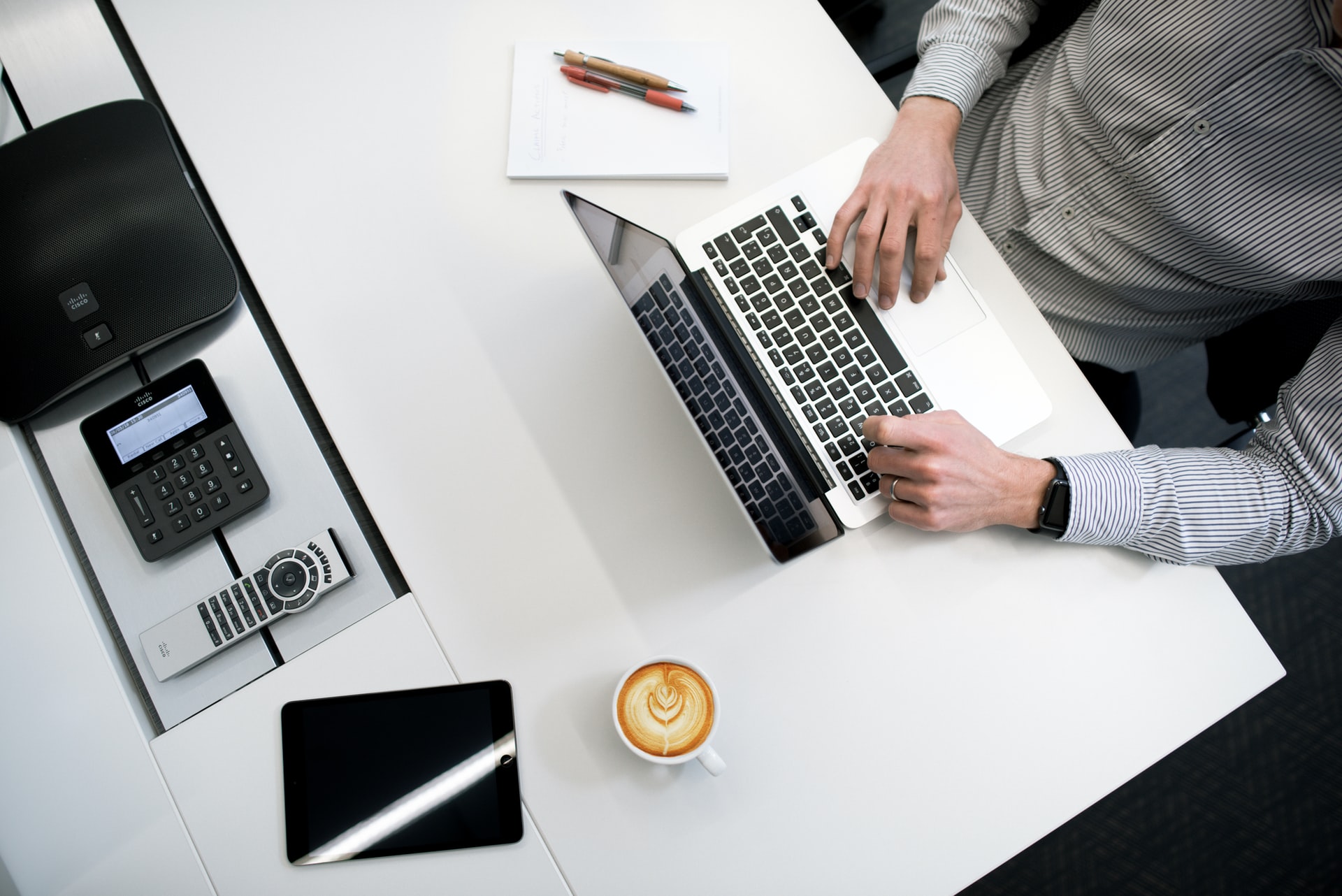 Man working on laptop on white office desk