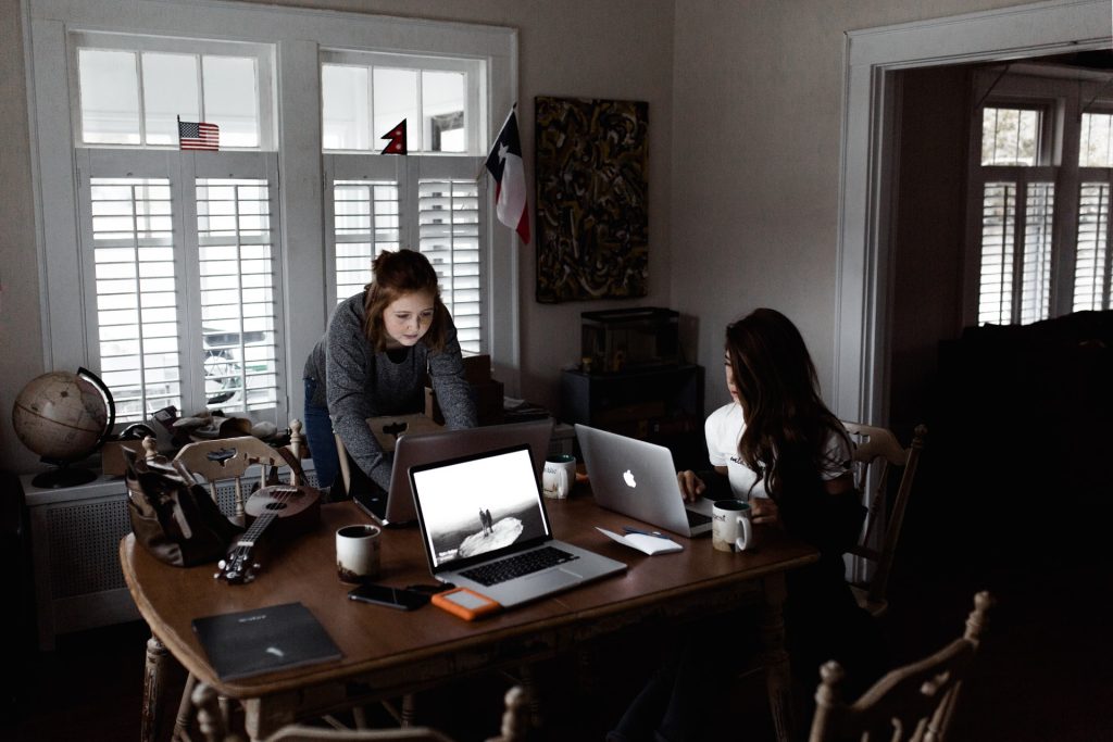 two girls working on laptops