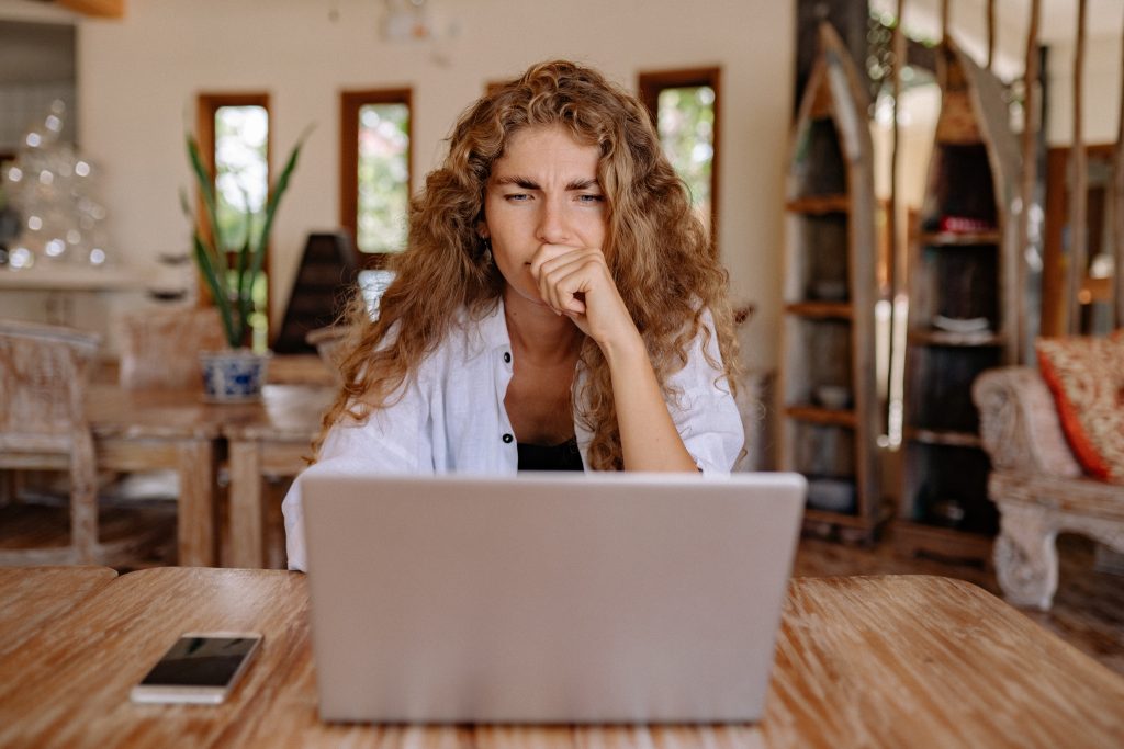girl in white shirt using laptop