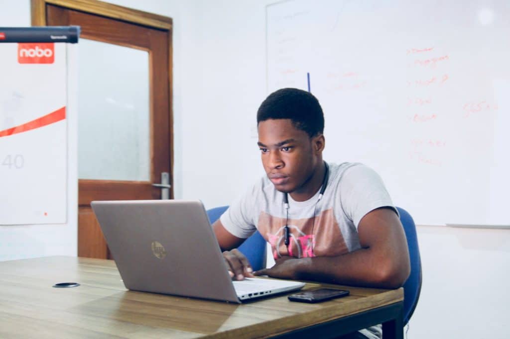 man in grey shirt using hp laptop