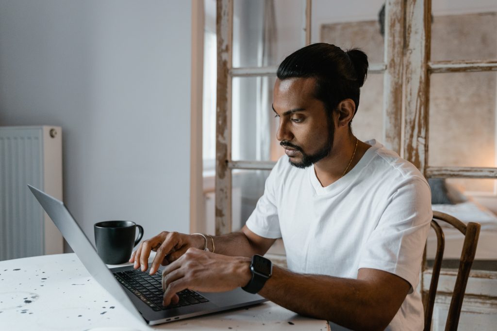 man serious typing on laptop