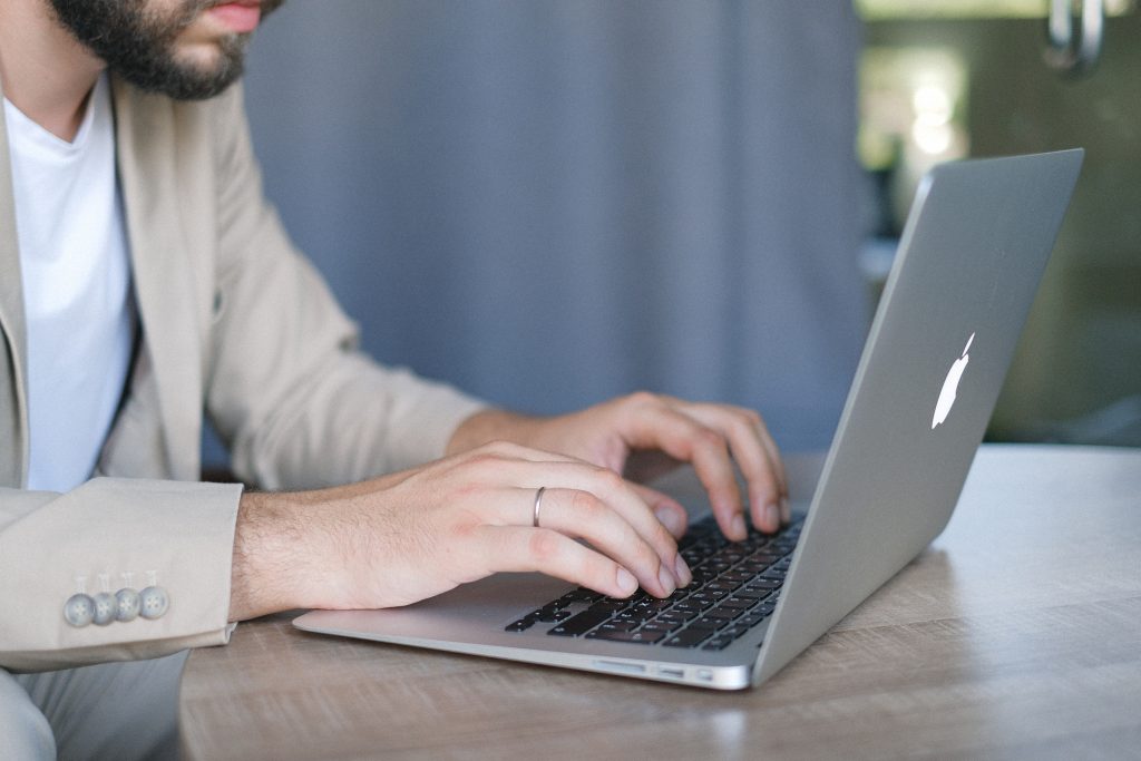 Man with beard working on silver macbook