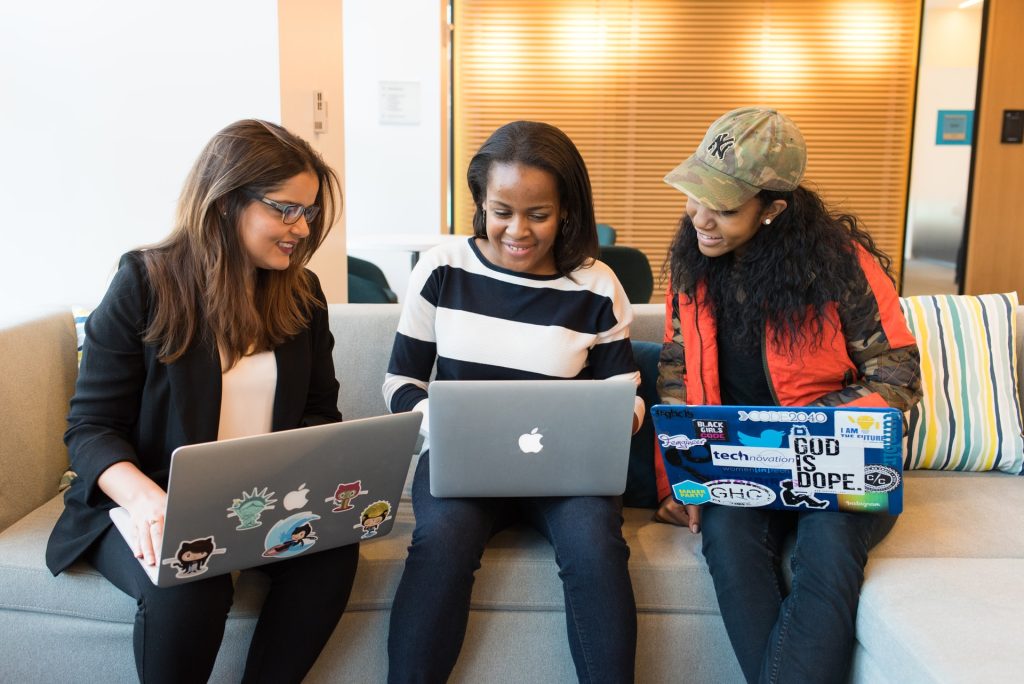 three girls working together on their laptops