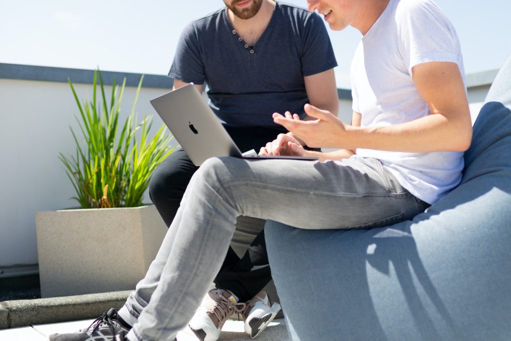 two man in blue and white shirt using laptop