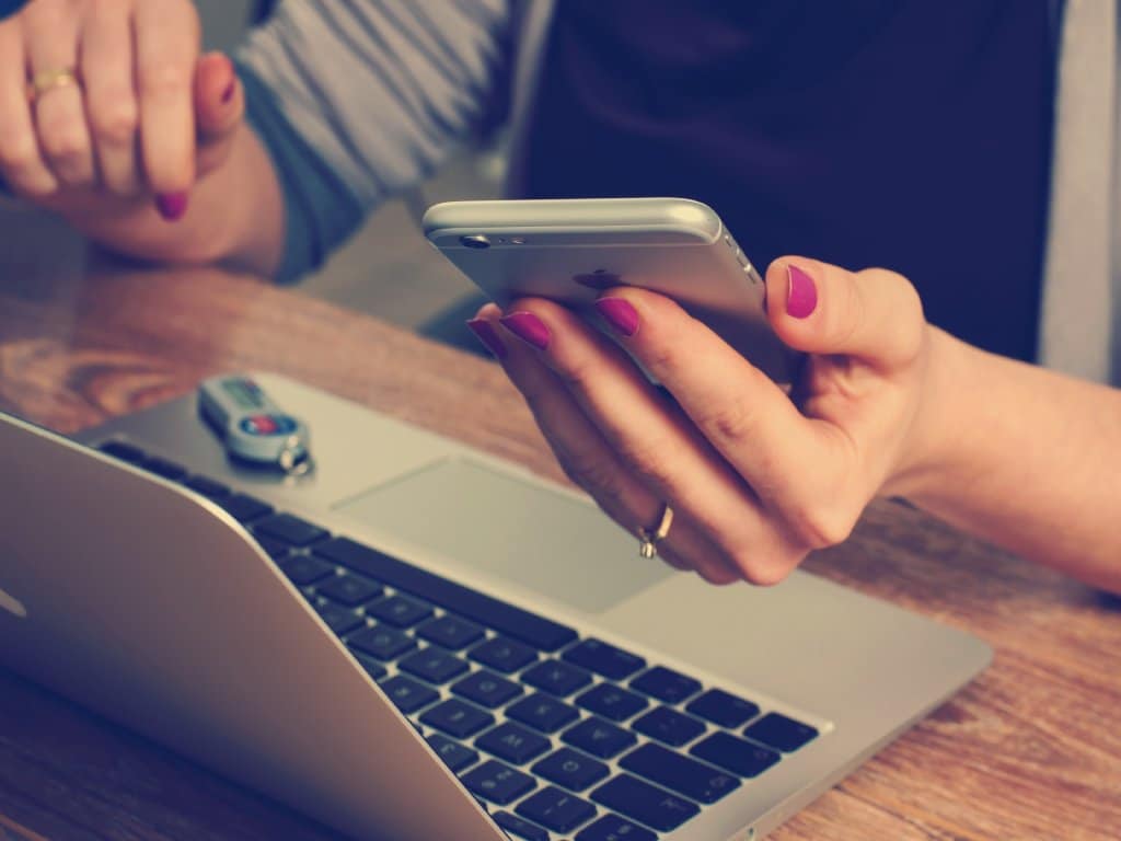 Woman with smartphone and laptop